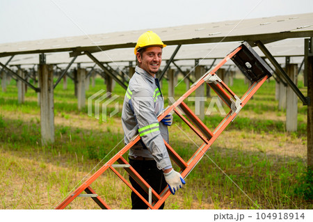 Maintenance technician checking solar panels on solar cell farm Maintenance technician checking solar panels on solar cell farm 104918914