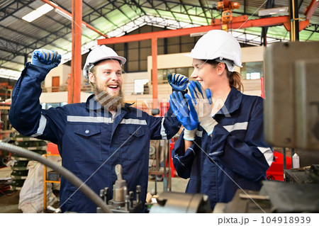 Mechanical engineers repairing engine machine at factory Mechanical engineers repairing engine machine at factory 104918939