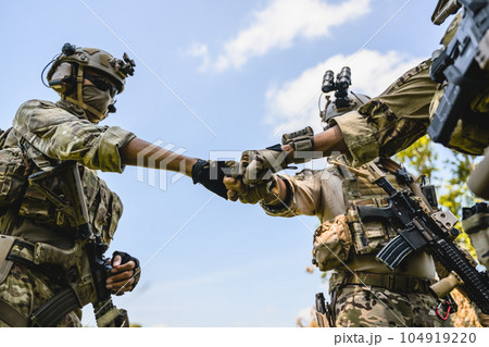 Squad of soldiers with teamwork stacking hands together 104919220