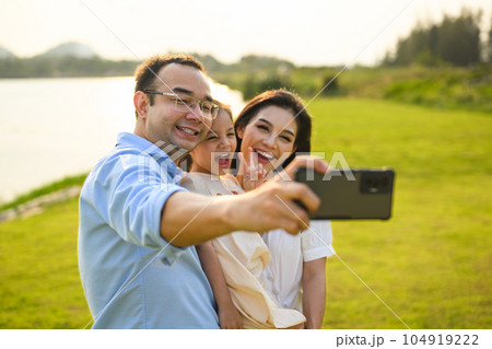 Family taking selfie photo together with green meadow and river view Family taking selfie photo together with green meadow and river view 104919222