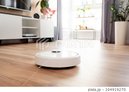 White robot vaccum cleaner in the living room 104919270