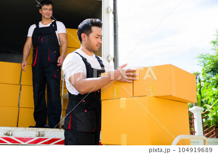 Happy two delivery men in front of delivery truck, Delivery men checking order of moving service and relocation service Happy two delivery men in front of delivery truck, Delivery men checking order of moving service and relocation service 104919689