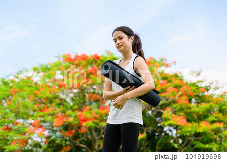 Healthy young woman enjoying and relaxing yoga outdoor in green park 104919698