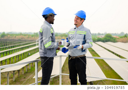 Happy maintenance engineers checking and maintaining solar panels Happy maintenance engineers checking and maintaining solar panels 104919785