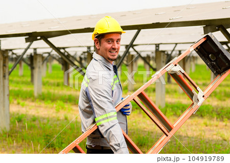 Maintenance technician checking solar panels on solar cell farm 104919789