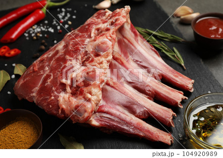 Raw ribs with spices on slate board, closeup 104920989