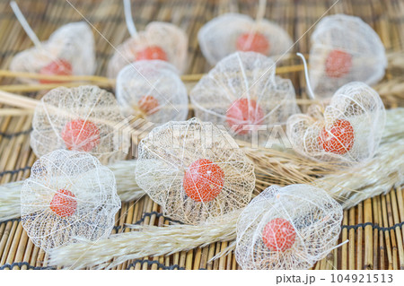 すだれにの上にたくさんの透かしホオズキ。ムギ、パンパスグラスのドライフラワーを添えて。 104921513