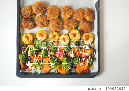 Ears of corn baked with herbs on white baking paper Ears of corn baked with herbs on white baking paper 104922053
