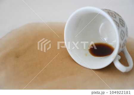 cup of coffee spilled on white bed  104922181