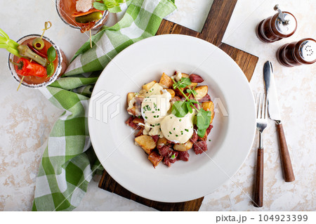 Breakfast potatoes with eggs Benedict and beef 104923399