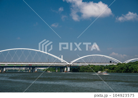 淀川にかかるモノレールの鉄橋と川を上る船 104923575