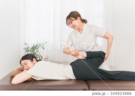 整骨院で骨盤矯正をする整体師・マッサージ師・セラピストの女性 104925666