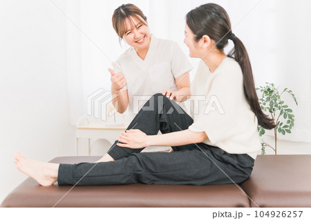膝・足の怪我が完治した患者と整形外科・整体院で働く整体師・マッサージ師・医師の女性 104926257