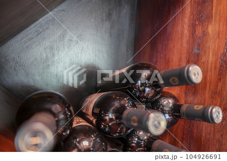 Bottled luxury wine capped with bottle tops viewed from top on wooden table at a restaurant in Costa Rica 104926691