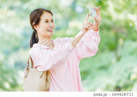 スマホで自撮りするミドル女性 104926711