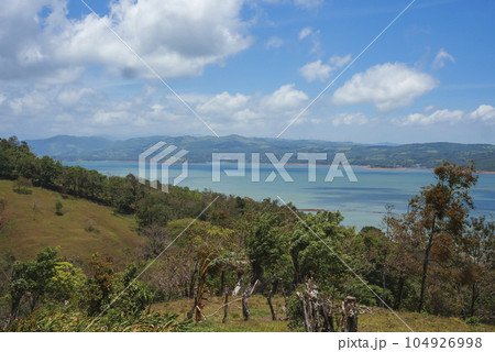 Scenic view of seascape amidst trees and mountain landscape under cloudy sky at Costa Rica 104926998