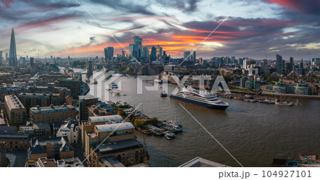 Large cruise ship going through London under the Tower Bridge. Visiting center of London. Tower bridge lifting up to let the ship enter London city center. Large cruise ship going through London under the Tower Bridge. Visiting center of London. Tower bridge lifting up to let the ship enter London city center. 104927101