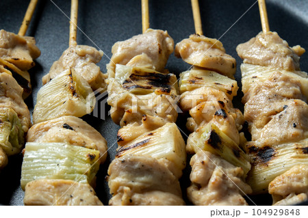 焼鳥(ねぎま串)をフライパンで温め直す調理シーン。 104929848