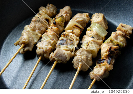 焼鳥(ねぎま串)をフライパンで温め直す調理シーン。 104929850