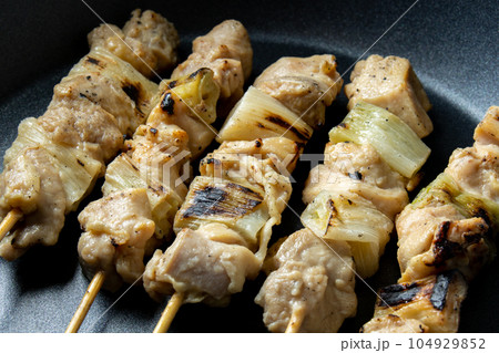 焼鳥(ねぎま串)をフライパンで温め直す調理シーン。 104929852