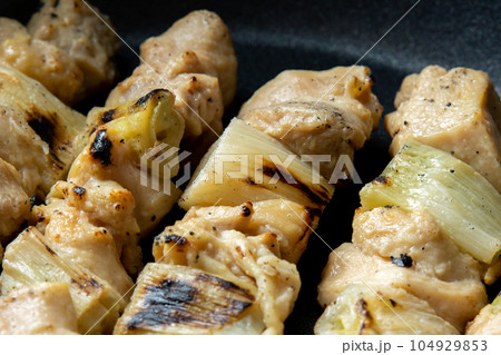 焼鳥(ねぎま串)をフライパンで温め直す調理シーン。 104929853