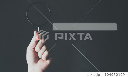 Search Engine Optimization, Search bar on virtual screen with hand holding magnifying glass. 104930199