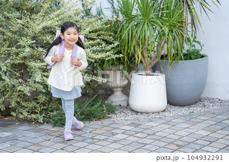 ランドセルを持って登校するカメラ目線の子供 ランドセルを持って登校するカメラ目線の子供 104932291