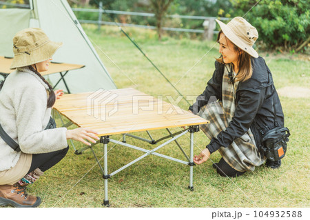 キャンプテーブルの組み立て・片付けをする女性キャンパー キャンプテーブルの組み立て・片付けをする女性キャンパー 104932588