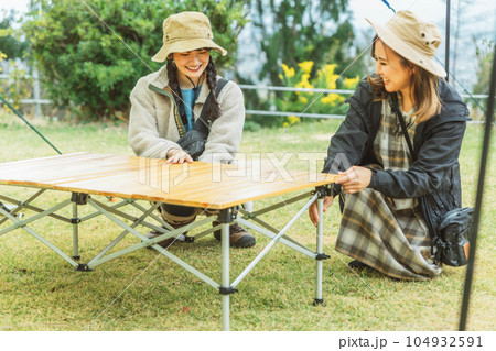 キャンプテーブルの組み立て・片付けをする女性キャンパー キャンプテーブルの組み立て・片付けをする女性キャンパー 104932591