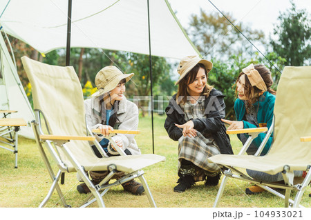 キャンプの椅子を組み立て・片付けをする女性キャンパー 104933021