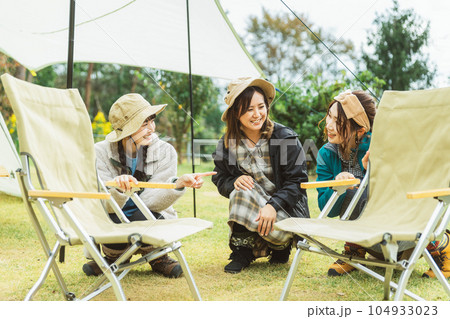 キャンプの椅子を組み立て・片付けをする女性キャンパー キャンプの椅子を組み立て・片付けをする女性キャンパー 104933023