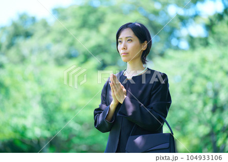 喪服姿で合掌する女性 104933106