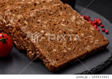Delicious fresh crispy brown bread with seeds and grains cut into slices 104933981