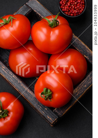 Delicious fresh juicy tomatoes on a dark concrete background 104933999