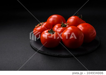 Delicious fresh juicy tomatoes on a dark concrete background 104934006