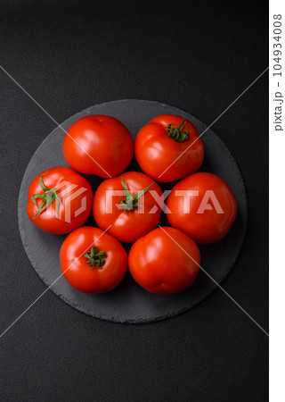Delicious fresh juicy tomatoes on a dark concrete background 104934008