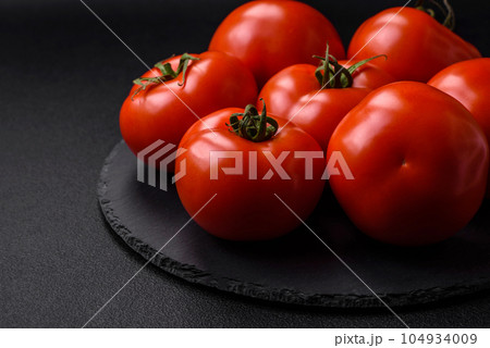Delicious fresh juicy tomatoes on a dark concrete background 104934009
