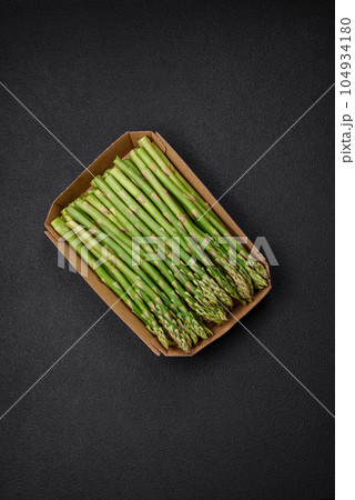 Delicious fresh sprigs of asparagus on a dark textured background 104934180