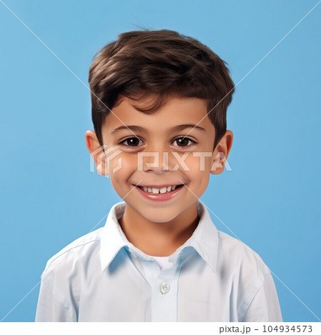 Portrait of a smiling little boy with brown hair. Closeup face of a handsome  small kid smiling at the camera on a blue background. Front view, happy male Arab child in a white shirt. 104934573