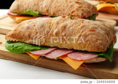 Chiabatta sandwich with ham and cheese on wooden board Chiabatta sandwich with ham and cheese on wooden board 104934889