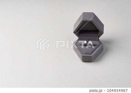 Golden ring in jewelry box on gray background 104934967