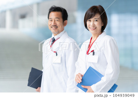 病院で打ち合わせをする男女のミドルの医者 104939049