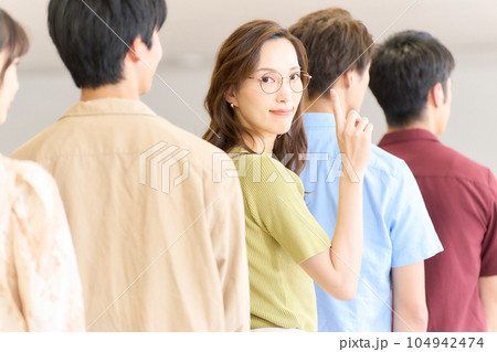行列に並びながら視線を向ける若い女性 行列に並びながら視線を向ける若い女性 104942474