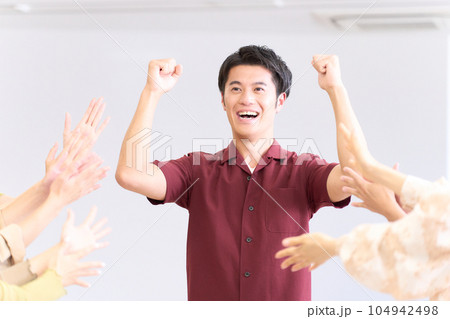 称賛を受けてガッツポーズを決める若い男性 称賛を受けてガッツポーズを決める若い男性 104942498