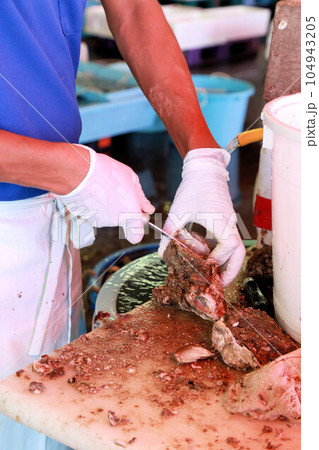 生牡蠣をその場で食べられる魚市場にてカキの殻をむいている場面 104943205