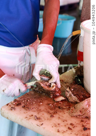生牡蠣をその場で食べられる魚市場にてカキの殻をむいている場面 104943206