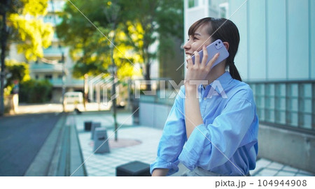 屋外でスマホで会話をするイメージ 104944908