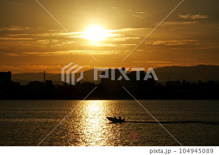 朝陽が反射する川と釣り船・冬・221210am 104945089