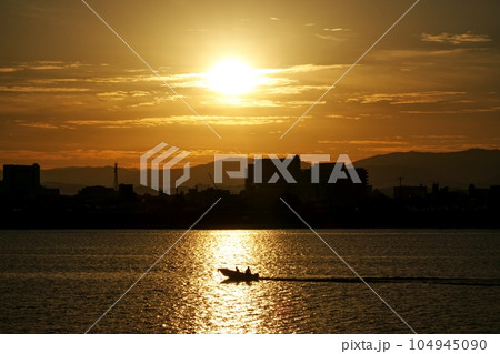 朝陽が反射する川と釣り船・冬・221210am 104945090