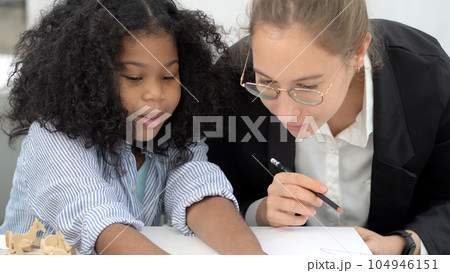 Creative class in diversity school Caucasian teacher with African kid having fun learning critical thinking global citizen education concept Creative class in diversity school Caucasian teacher with African kid having fun learning critical thinking global citizen education concept 104946151